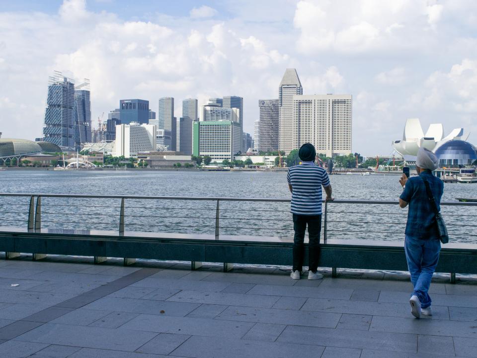 Two men take photos in Singapore. Photo by Kate Toretti.