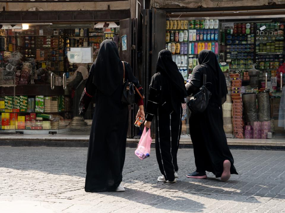 Women walk among shops. Photo by RJ Rempel.