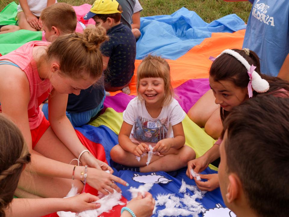 A child smiles while making a craft at a children's programme. Photo by Jordan Wilkinson.