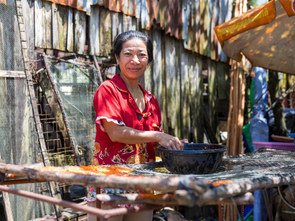 Sihanoukville, Cambodia :: A local seller smiles while preparing to open for business.