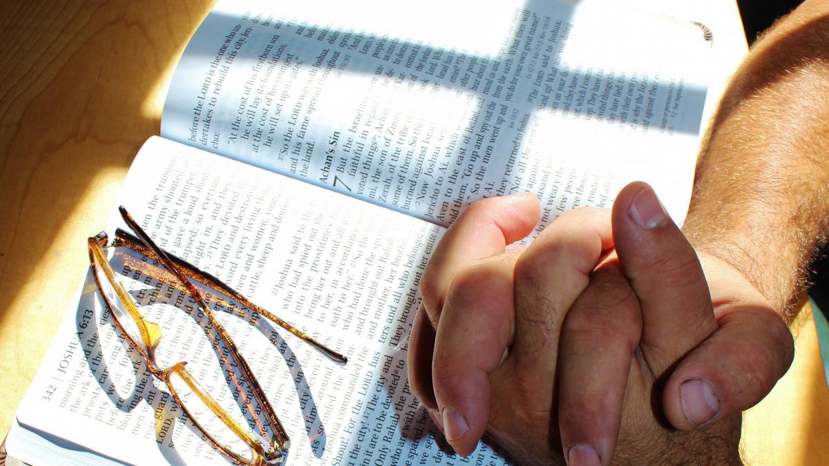 mani in preghiera sopra una bibbia