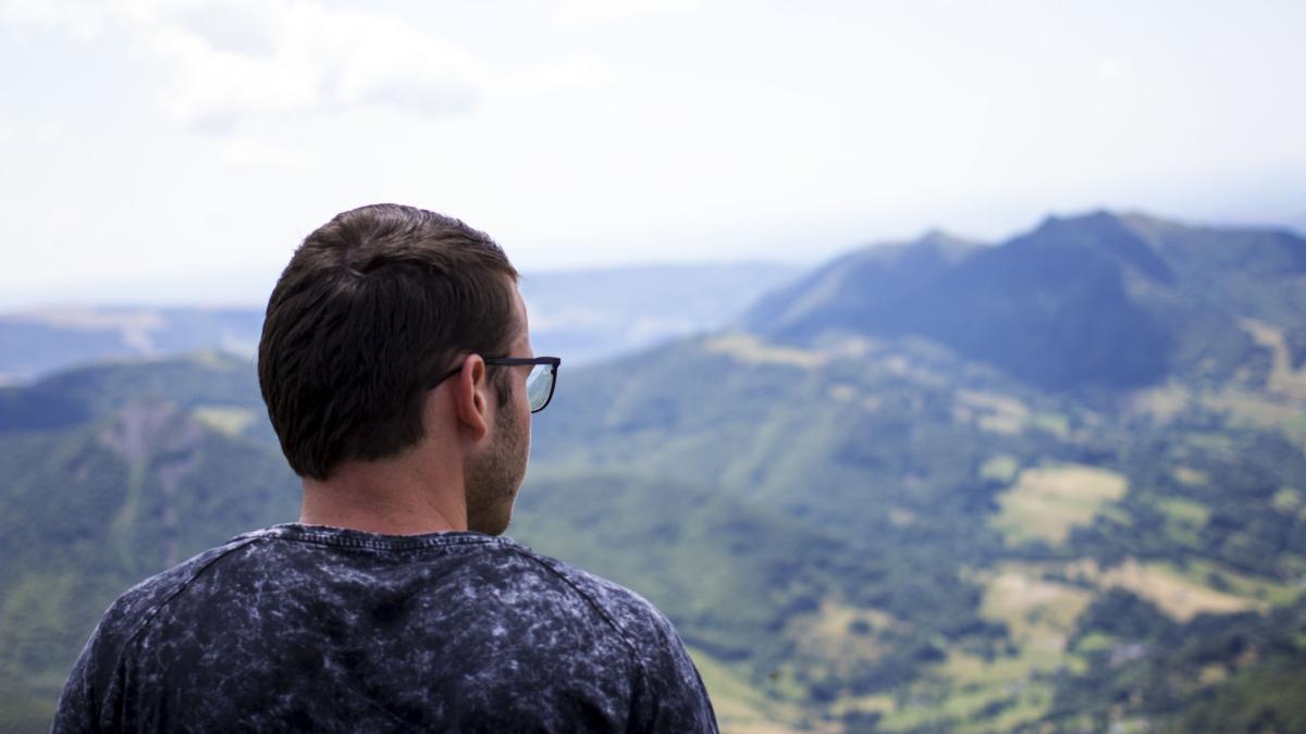 Norwegian young man sits and stares at God's creation on top of Puy Mary in the Cantal Region of France.