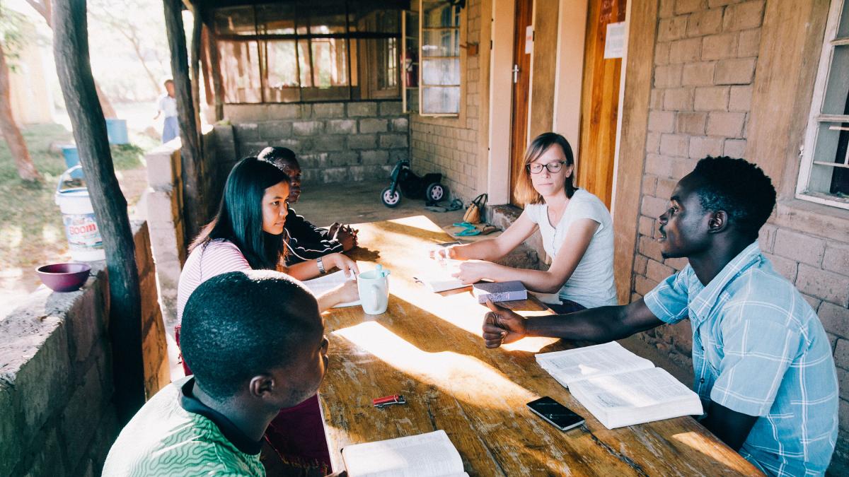 Ivy, in the striped shirt on the left, does a Bible study at Lake Tanganyika. Photo by Doseong Park.