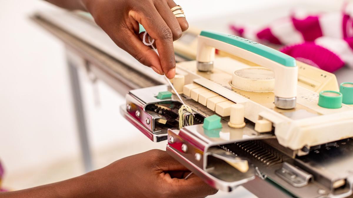 A woman working on a knitting machine in north-central Africa. Photo by RJ Rempel.