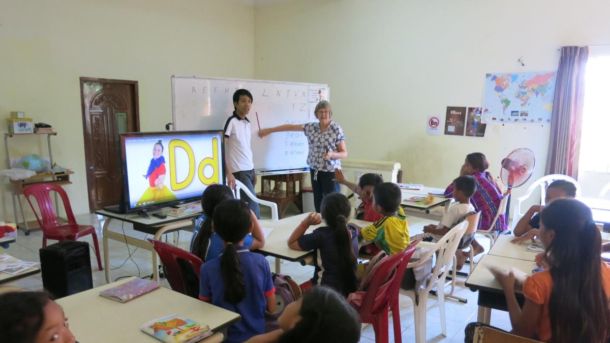 In their mid-sixties Kiwis Pam and Alan retired. Sort of. “You don’t retire and suddenly that’s it,” Alan explained. “You just continue on involved in the Kingdom but with some changes.” Pictured is Pam helping teach English in Cambodia. Photo submitted b