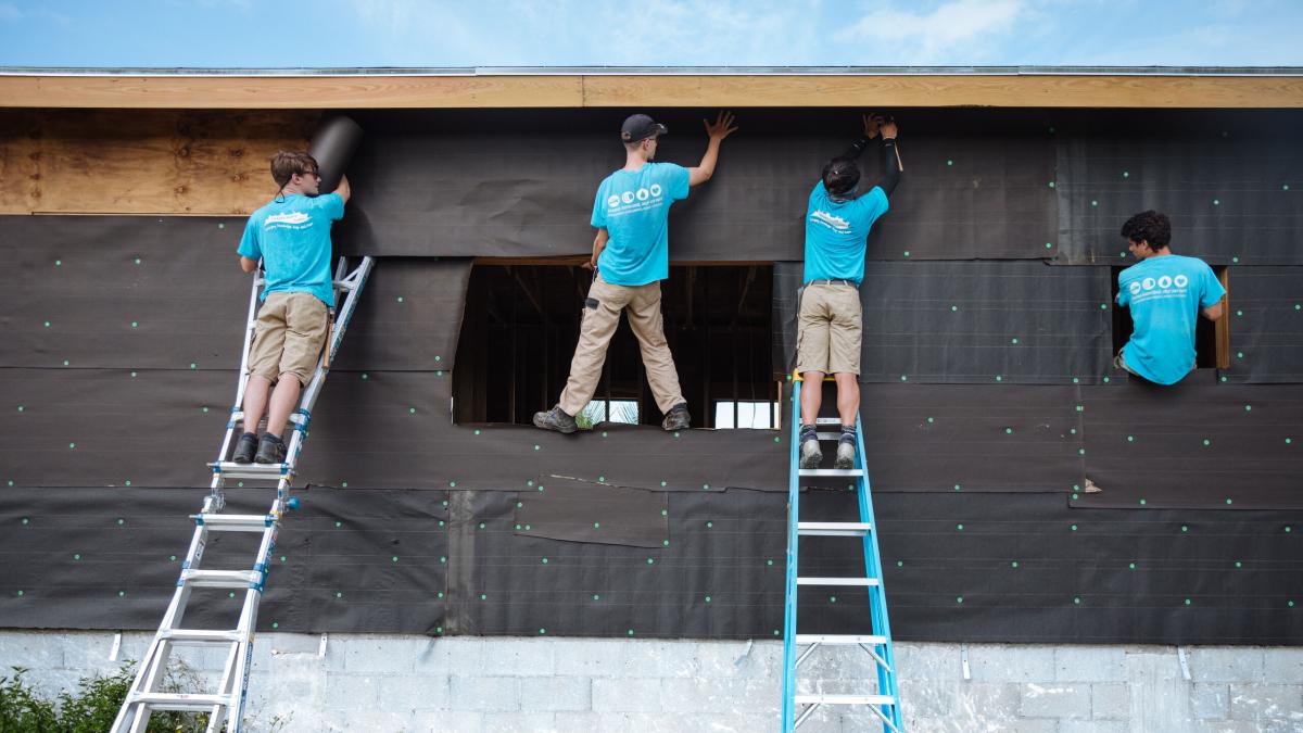Abaco, The Bahamas :: Crewmembers help to wrap a house to make it weather-proof after a hurricane destroyed homes in the Abaco Islands.