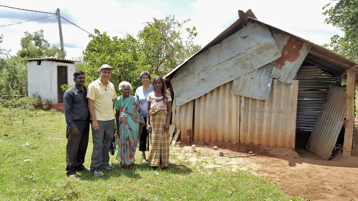 George (in yellow) with his wife Janet (behind in blue) in Sri Lanka visiting the war widows ministry. The woman in the centre of the photo is one of the first widows the ministry helped. After hearing her story from a local pastor (in black), they helped