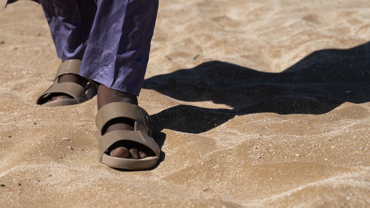 A man from the Sahel walks through sand. Photo by RJ Rempel.