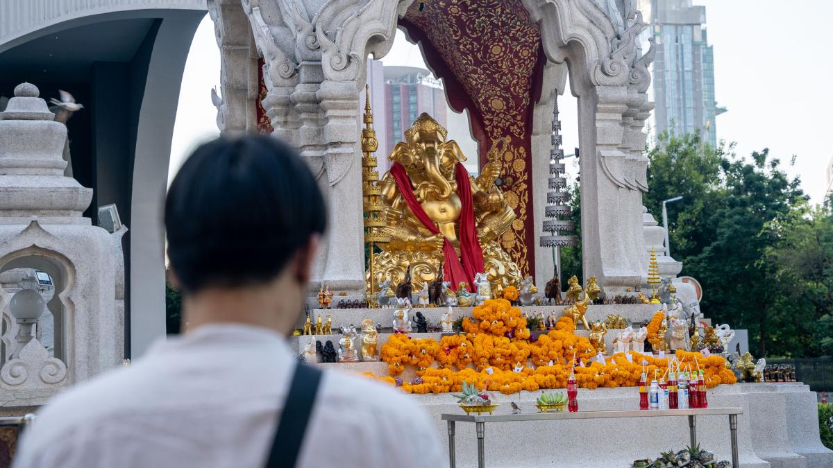 Man praying at a Buddhist shrine in Thailand. Photo by RJ Rempel.