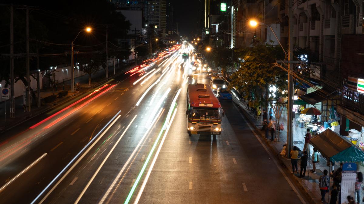 A bus makes a stop at night in Bangkok, Thailand. Photo by RJ Rempel.