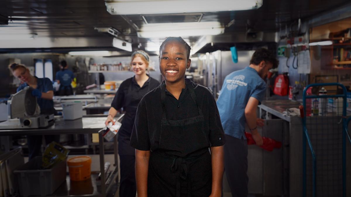 Vlorë, Albania :: Abigail (Zimbabwe) smiles for a photo during a shift on board Logos Hope in the galley