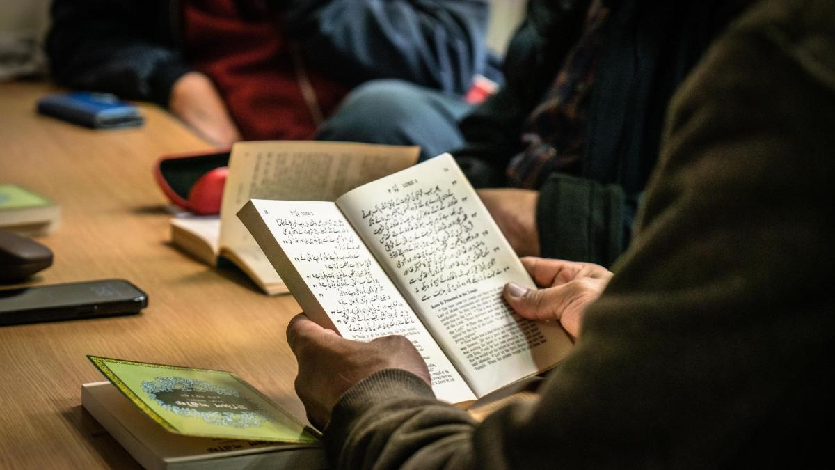 A group of men read the Bible in Arabic together. Photo by James Blake.