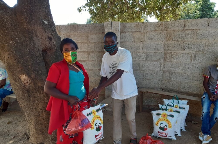 OM-Mitarbeiter in Sambia verteilt Lebensmittel