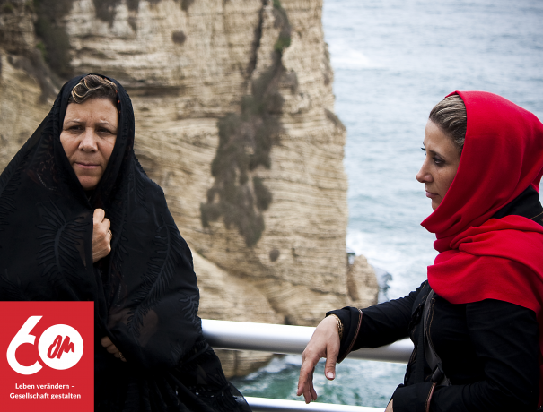 Zwei Iranische Frauen am Meer mit einem Felsen im Hintergrund
