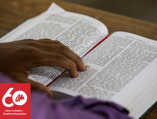 aufgeschlagene bengalische Bibel, mit der Hand des Lesers