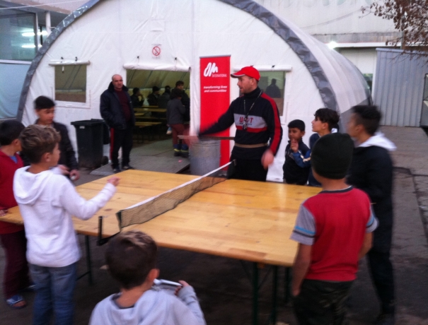 OM-Mitarbeiter bringt im OM-Zelt Flüchtlingskinder Tischtennisspielen bei