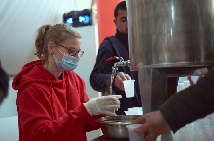 OM-Mitarbeiterin gibt im Flüchtlingslager in Serbien Tee aus