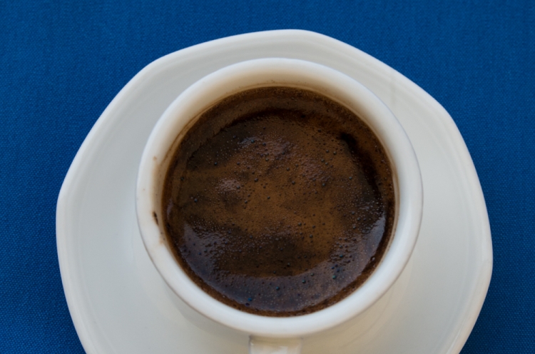 Eine Tasse mit arabischem Kaffee. Die Tasse ist aus weißem Prozellan auf blauem Hintergrund.