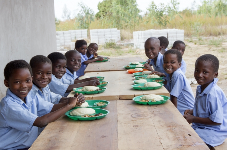 Schulkinder in Malawi freuen sich über eine warme Mahlzeit.