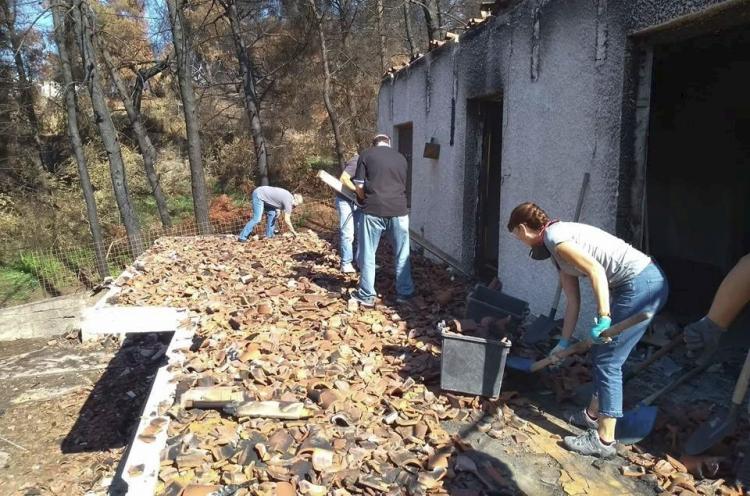 Church members cleaning a house collapsed due the wildfires